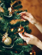 © Duet Postscriptum/Stocksy - Person decorating Christmas tree