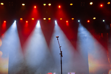 Wall Mural - Microphone on the background of the illuminated concert stage. Empty music scene. Karaoke.