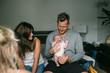 © Rob and Julia Campbell/Stocksy - Young parents with screaming newborn baby in bedroom
