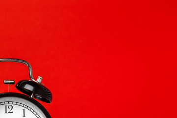 black vintage alarm clock on color background