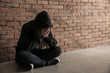 © Pixel-Shot - Depressed female junkie near brick wall. Concept of addiction