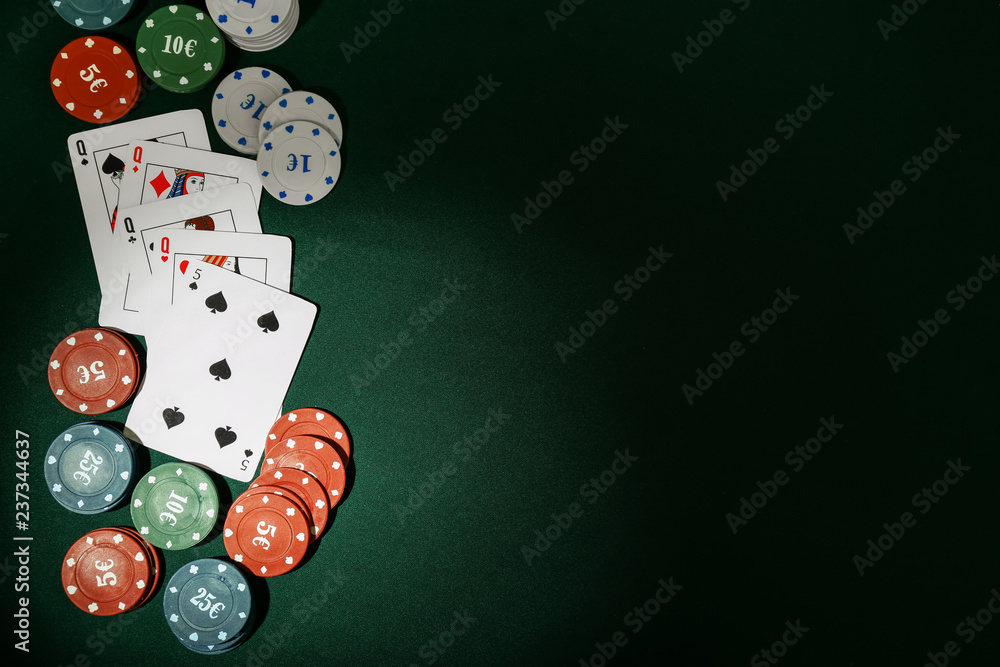Chips with cards for poker game on green table