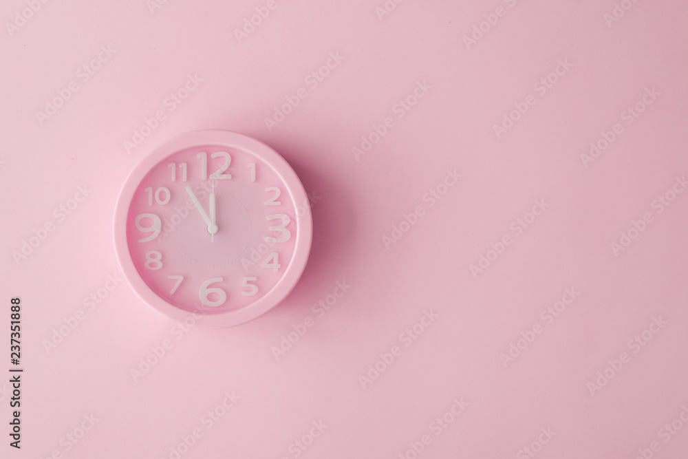 Pastel pink clock on pink painted wall. Minimal time concept. Chrismas eve or new year idea. - obrazy, fototapety, plakaty 