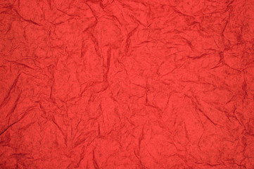 ABSTRACT RANDOM BACKGROUND OF CREASED CRUMPLED BRIGHT RED TISSUE PAPER