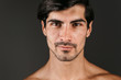 © Drobot Dean - Naked young smiling man posing isolated over dark wall background.