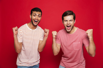 Canvas Print - Two cheerful young men standing isolated over red