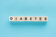 © LIGHTFIELD STUDIOS - top view of 'diabetes' lettering made of wooden cubes in line on blue background