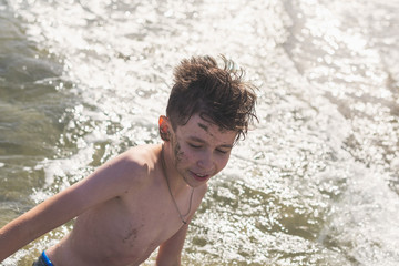 Wall Mural - boy in the sea wave. Travel and summer concept