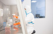 © Westend61 - Lab technician wearing cleanroom overall working in sterile laminar box