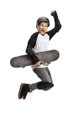 Wall Mural - Young skater holding a skateboard and jumping
