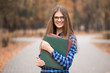 © Svetlana - Youthful positive cheerful confident energetic female college student on way to class with folders