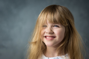 Wall Mural - smiling little blonde girl with fluttering hair