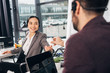 © LIGHTFIELD STUDIOS - call center operator giving bottle with medicine to smiling coworker in office