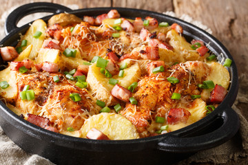 Delicious ranch casserole of chicken fillet with potatoes, bacon and cheese close-up in a pan. horizontal