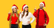 © luismolinero - A group of people Blonde woman dressed up for christmas holidays showing and lifting a finger in sign of the best on yellow background