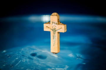 Concept of baptism and purification in the Christian religion, crucifix over the water surface