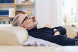 © contrastwerkstatt - Middle-aged man relaxing on a sofa at home