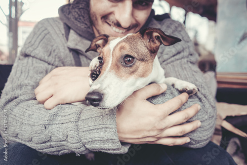 Fotografía Man cuddling with his terrier dog in winter