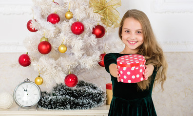 Child celebrate christmas at home. Favorite day of the year. Time to open christmas gifts. Merry christmas concept. Dreams come true. Best for our kids. Kid girl near christmas tree hold gift box