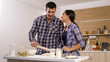 © DC Studio - Young wife giving affection to her husband while cooking. Sweet moment.