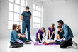 © rh2010 - Group of young people learning to make artificial breathing with medical dummies during the first aid training in the white room