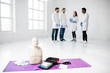 © rh2010 - First aid medical stuff and dummies with group of young medics standing during the break on the background