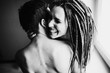 Young positive hipster couple without any clothes hugging each other. The girl has dreadlocks