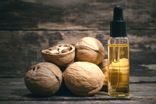 Walnut Oil In The Bottle On The Wooden Table Background.