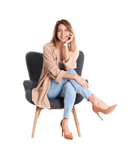 Young Woman Sitting In Armchair On White Background