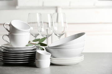 Set of clean dishes on table against blurred background