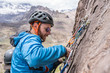 © abriendomundo - Face expressions while a climber climb a big wall inside the Andes, an amazing adventure. Smile on his faces while going to the mountain summit. Cajon del Arenas (Arenas Valley), Chile