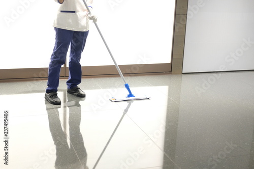 Uniformed Cleaner Wipes The Floor Using A Mop Kaufen Sie Dieses