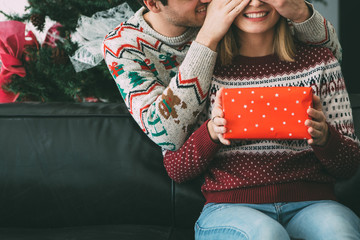 Wall Mural - Young man surprise woman with Christmas present