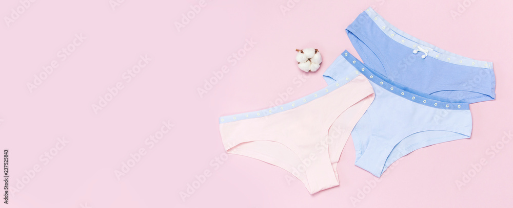 Female pastel cotton set panties and cotton flower on pink background top view flat lay with copy space for text. Fashion blog, Colorful women's natural underwear, advertising, shopping concept. - obrazy, fototapety, plakaty 