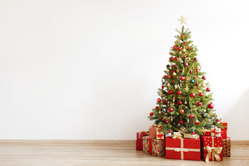 big beautiful christmas tree decorated with beautiful shiny baubles and many different presents on w