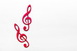 Red wooden treble clef on white background
