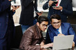 © AS Photo Family - Group of five indian business man in suits sitting at office on cafe looking at laptop and drinking coffee.