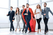 © ASDF - businessman in a red cloak marching with the business team