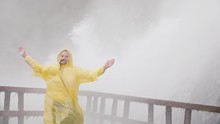 The Woman Is Pleased With The Splashes Of Water Under The Niagara Falls. Journey To The Cave Of The Winds. Slow Motion Video