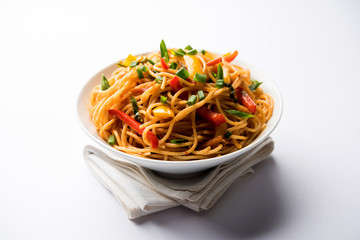 Canvas Print - Schezwan Noodles or vegetable Hakka Noodles or chow mein is a popular Indo-Chinese recipes, served in a bowl or plate with wooden chopsticks. selective focus