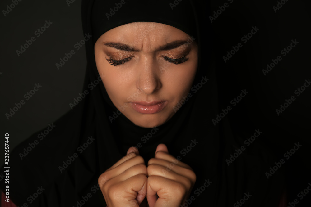 Portrait of sad Muslim woman in hijab praying on dark background Stock ...