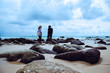 © last19 - Asian lover woman and man travel nature. Travel relax. On the rocks at the sea. In the summer. Thailand