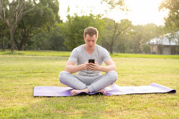 Young handsome man using phone at the park