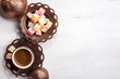 Traditional Turkish coffee and Turkish delight on white shabby wooden background. Top view.