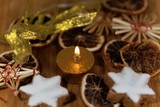Fototapeta Tulipany - Golden candle with Christmas cookies and decoration