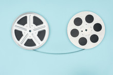 Film Reels With Cinema Tape Between Them Isolated On Blue