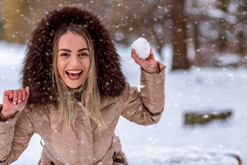 happy girl playing snowball fight on the winter snow day.