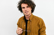© Z A C - Horizontal closeup portrait of handsome smart man with curly hair, with spectacles in hand posing for social advertisement, isolated on white wall with copy space for your promotional information.