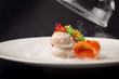 Molecular cuisine gravlax trout with garlic ice cream on a black background