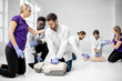 © rh2010 - Group of young medics practising to make artificial breathing with medical dummies during the first aid training in the white room